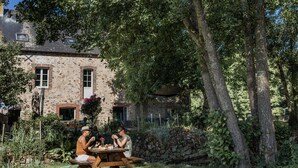 Un bâtiment rustique en pierre doté d’un patio avec jardin.