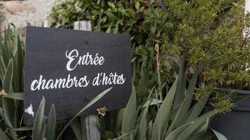 Une pancarte indiquant « Entrée : chambres d’hôtes » dans un cadre verdoyant.