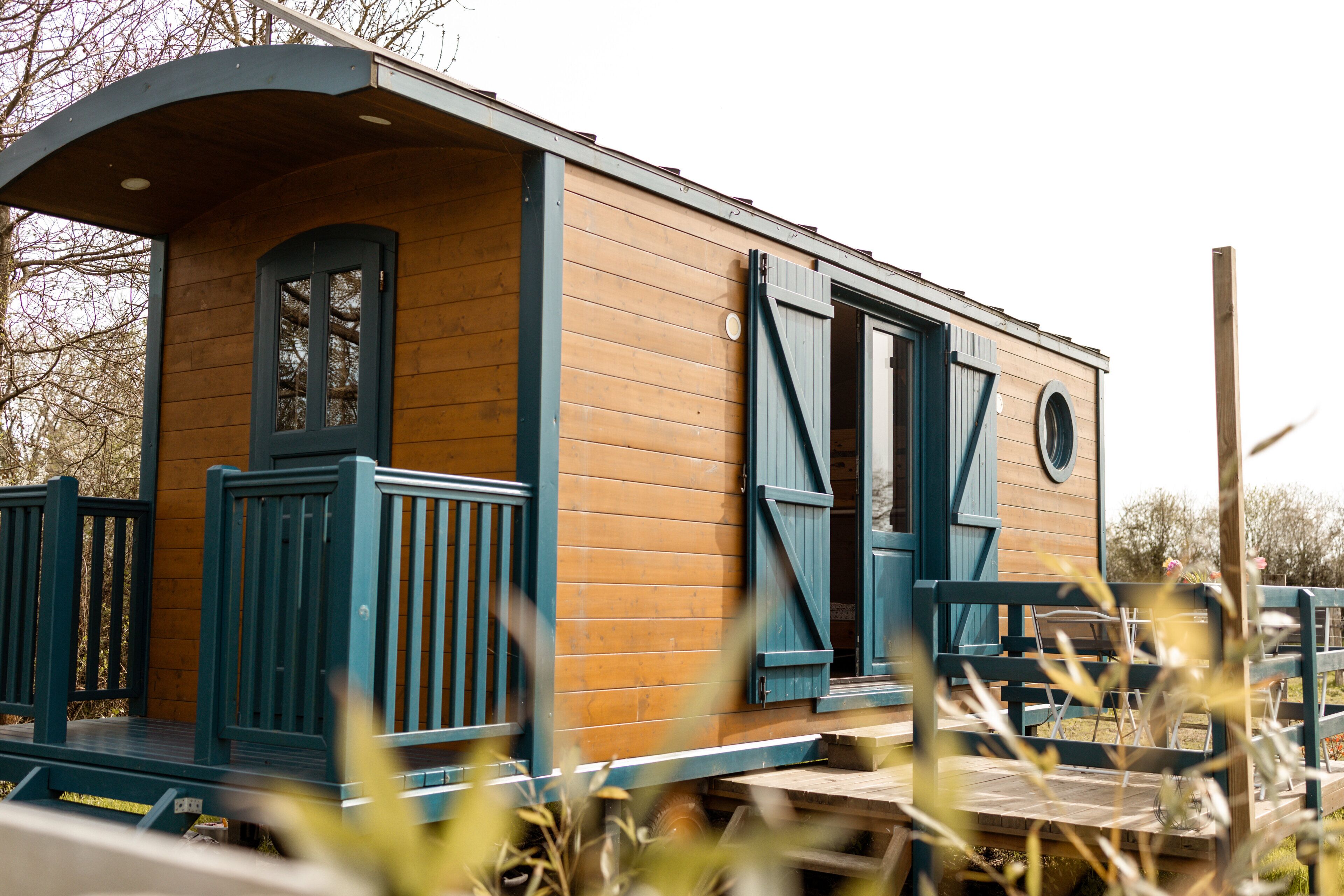 A wooden cabin with a porch and a door.