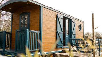 A wooden cabin with a porch and a door.