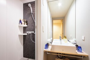 Ein modernes Badezimmer mit Dusche, Waschbecken und Spiegel.