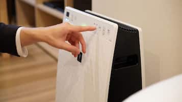 A hand interacting with a control panel on a device, likely a thermostat or control unit.