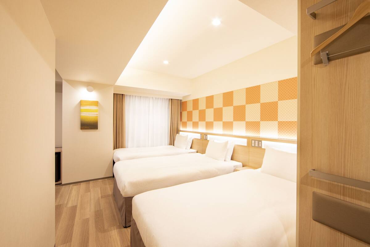 A hotel room with two beds, a checkered wall, and a modern design.
