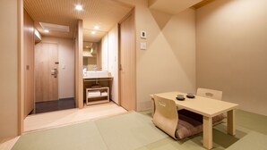A traditional Japanese room with tatami flooring, a low table with cushions, and a wooden cabinet. - karaksa hotel TOKYO STATION (Tokyo)
