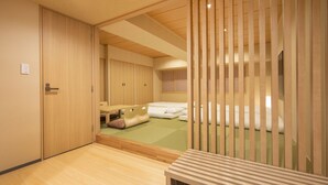 A traditional Japanese-style room with sliding doors, a tatami mat floor, and a low wooden bed. - karaksa hotel TOKYO STATION (Tokyo)