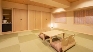 A traditional Japanese-style room with tatami flooring, a low table, and a futon bed. - karaksa hotel TOKYO STATION (Tokyo)