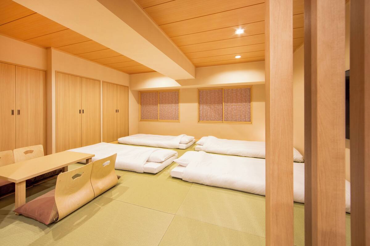 A traditional Japanese-style room with tatami flooring, wooden furniture, and sliding doors.
