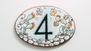 Una placa decorativa amb el número 4, envoltada de motius florals i de fulles.