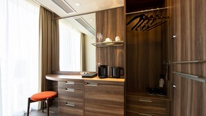 A modern room with a wooden vanity, a small table with a coffee maker, and a chair. - karaksa hotel premier Tokyo Ginza (Tokyo)