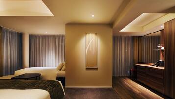 A hotel room with a bed, a desk, a chair, a mirror, and a wall-mounted artwork.
