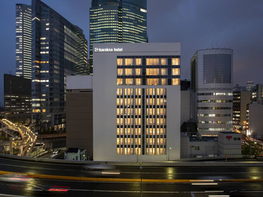 Un bâtiment moderne avec une enseigne indiquant « Hôtel Karaksa » et une façade en verre.