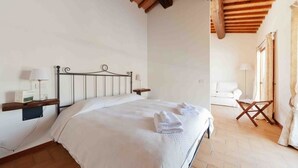 A bedroom with a bed, bedside tables, a lamp, and a wooden ceiling. - La Perticara (Acquasparta)