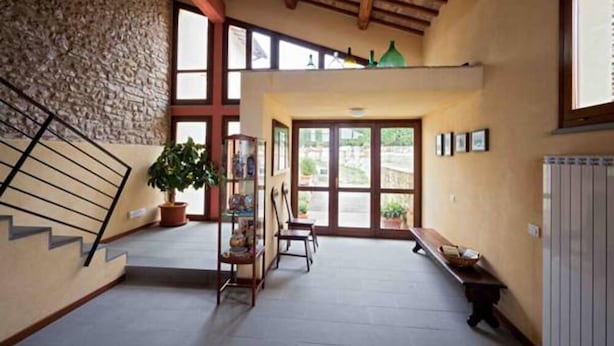 A spacious interior with a stone wall, wooden staircase, and a bench. - La Perticara (Acquasparta)