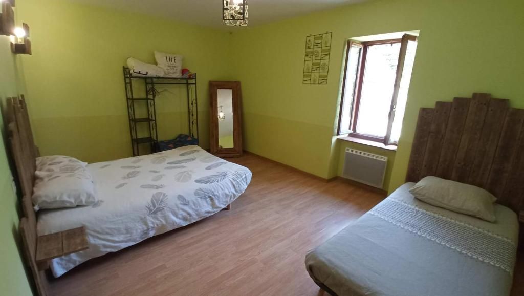 A room with two beds, a bunk bed, a window, and a mirror.
