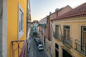 Una stretta via fiancheggiata da edifici e auto parcheggiate.