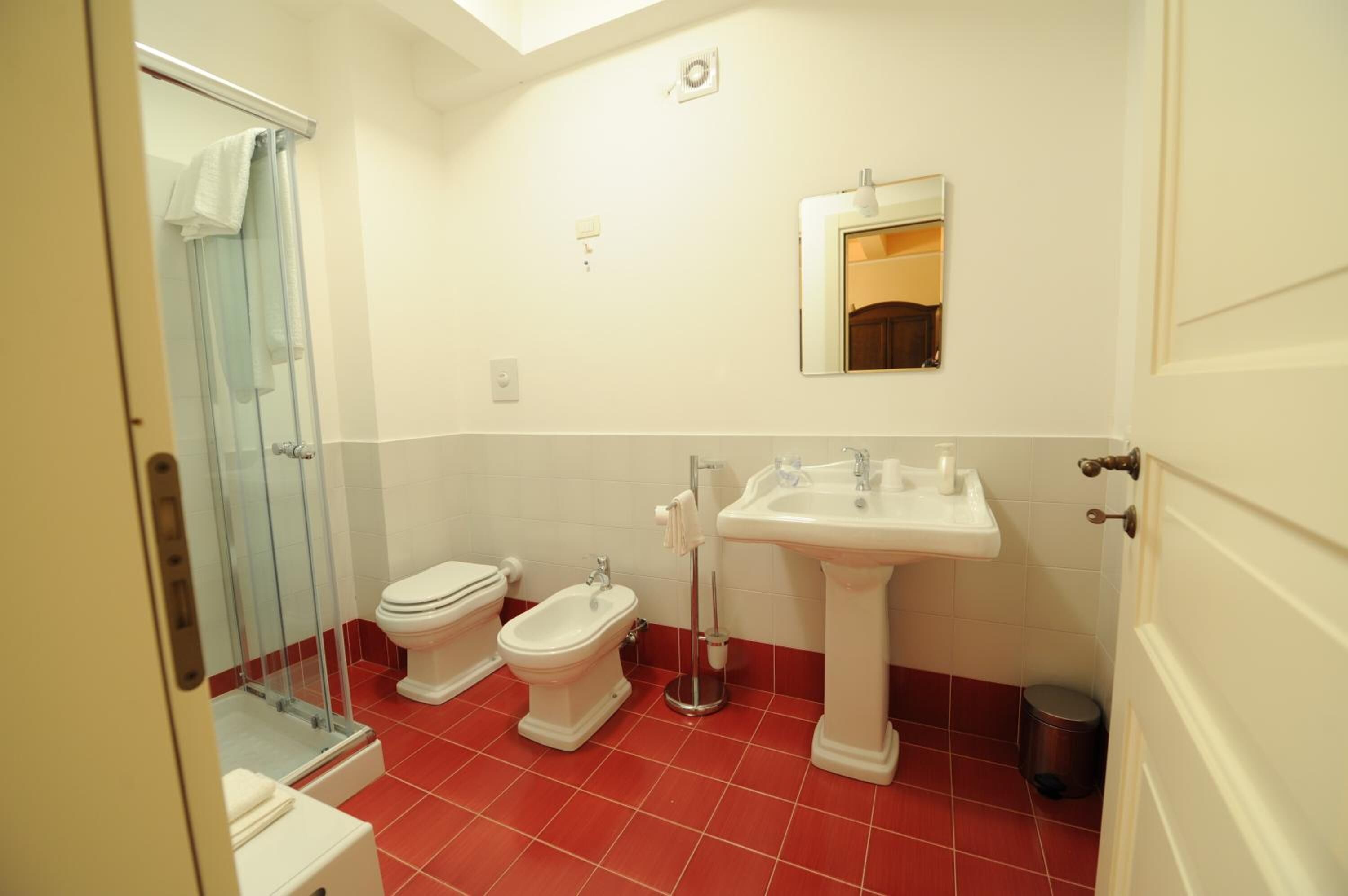Ein Badezimmer mit Dusche, Toilette, Bidet und Waschbecken.
