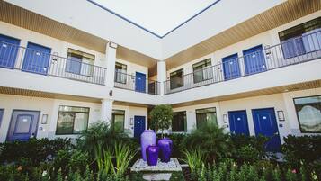 Ein mehrgeschossiges Hotel mit blauen Türen und Balkonen.