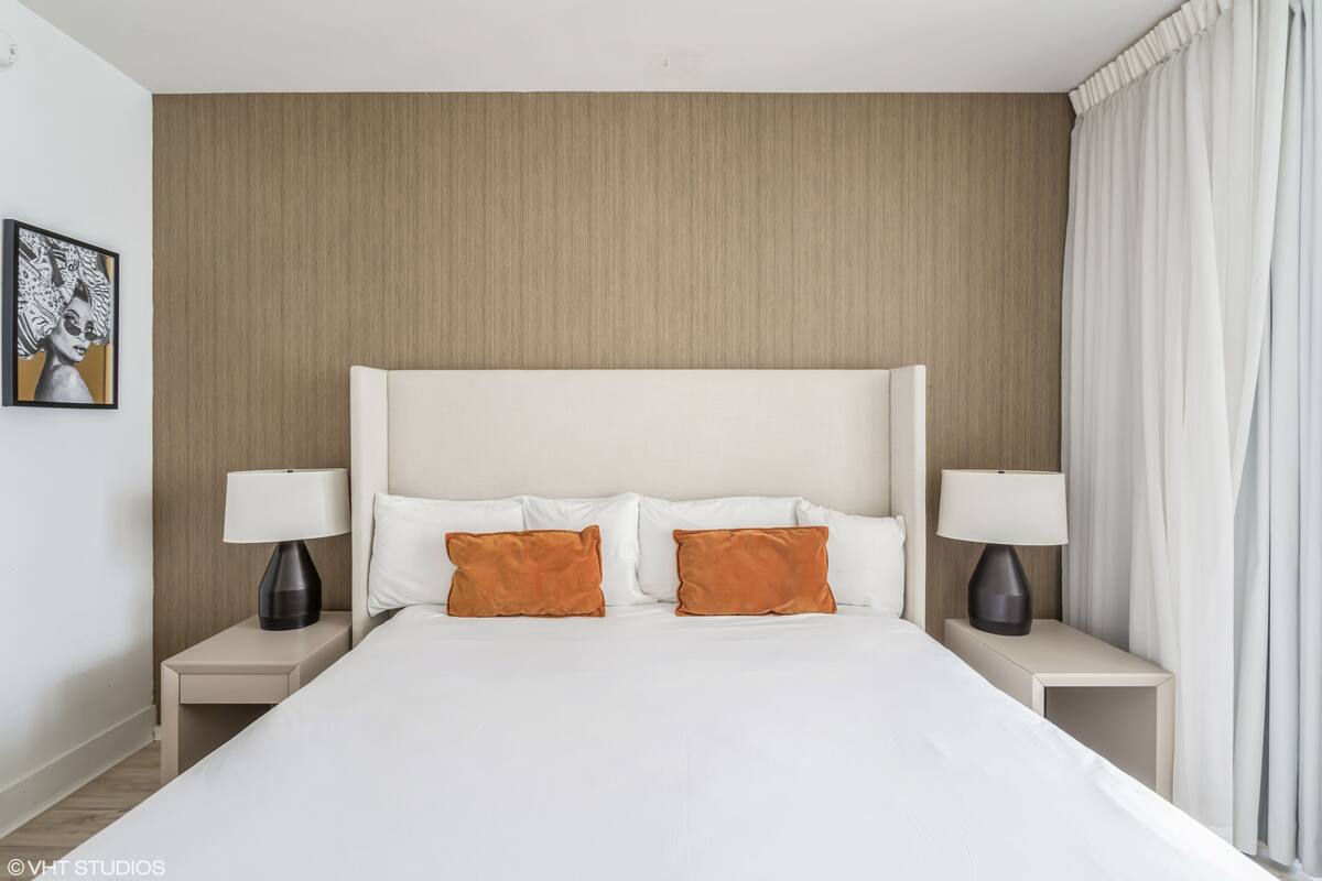 A hotel room with a large bed, two nightstands, and a headboard.