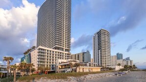 A modern hotel with a curved facade, multiple floors, and a beachside location. - Lyfe Residence Building - Private apts over the beach (Hollywood)