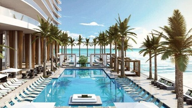 A modern pool area with lounge chairs and palm trees, overlooking the ocean. - Lyfe Residence Building - Private apts over the beach (Hollywood)
