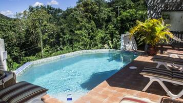 Alberca al aire libre, sombrillas en la alberca y camastros