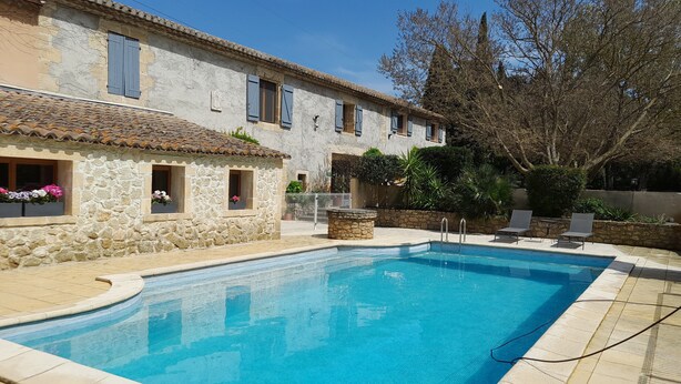 Une piscine avec un bâtiment en pierre en arrière-plan.