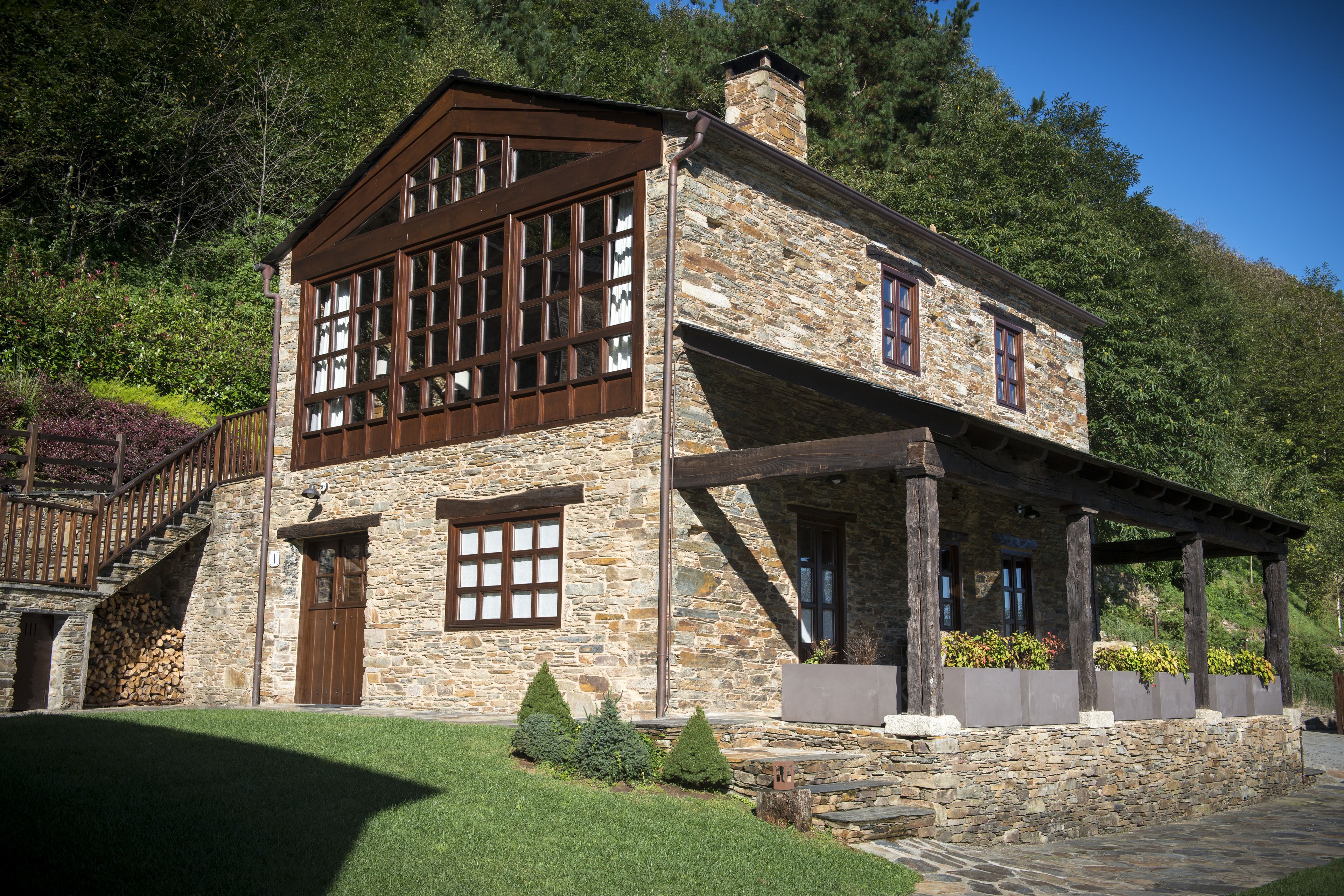 A stone building with a wooden balcony and a staircase leading to a door.
