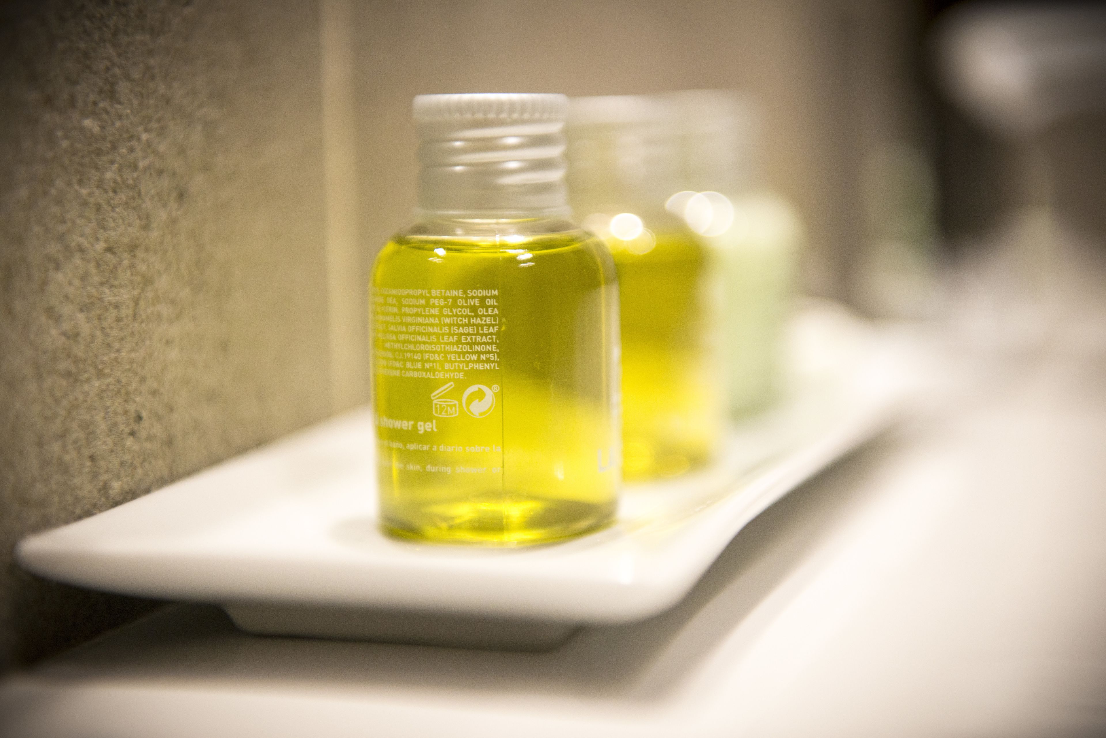 Une étagère de salle de bain avec trois bouteilles de gel douche.