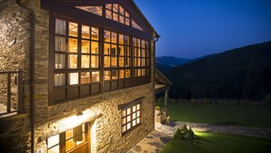 Un edificio de piedra con ventanas amplias y una escalera de piedra que conduce a la entrada.