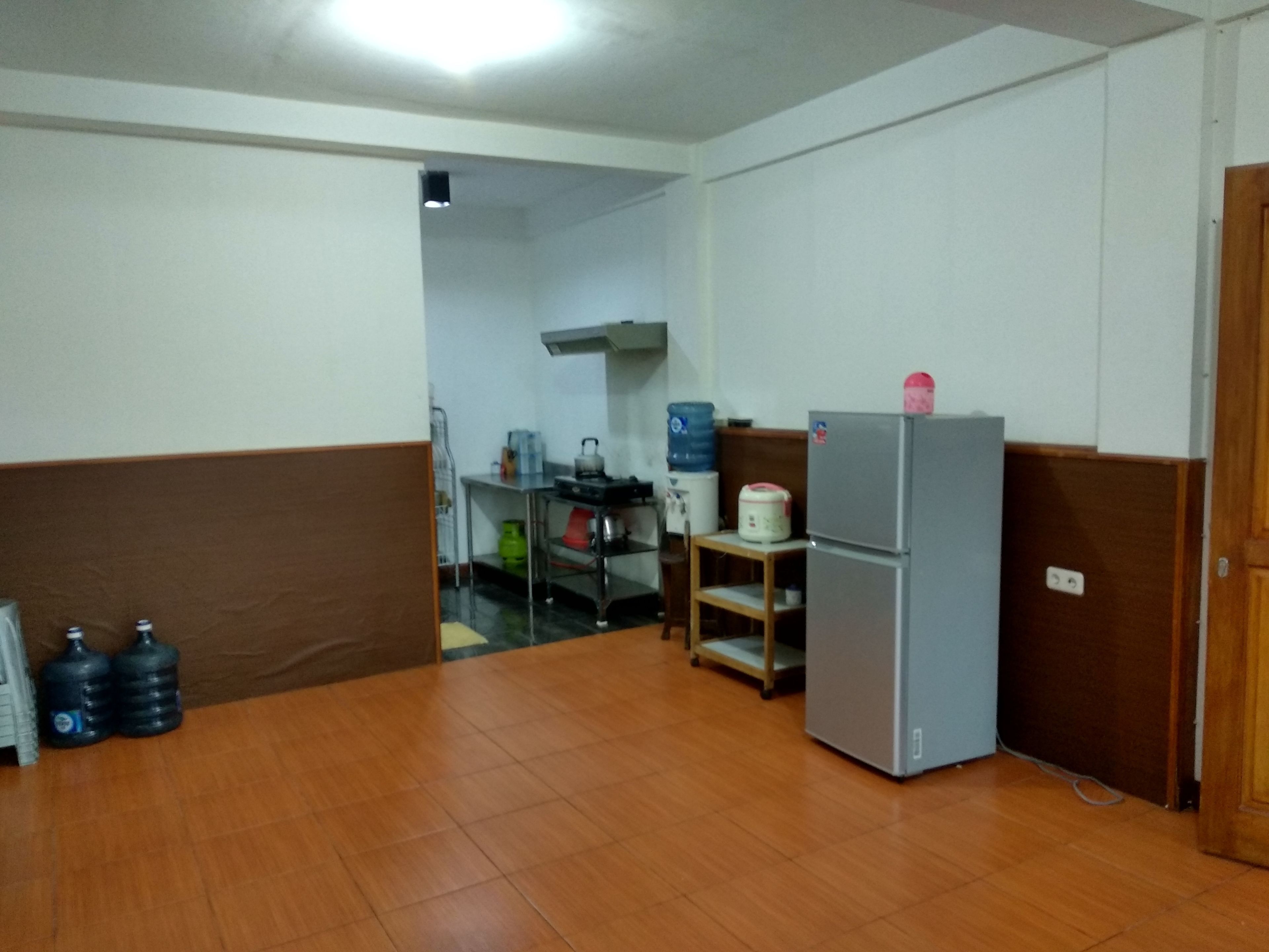 A kitchen with a refrigerator, water dispensers, and a sink.