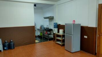 A kitchen with a refrigerator, water dispensers, and a sink.