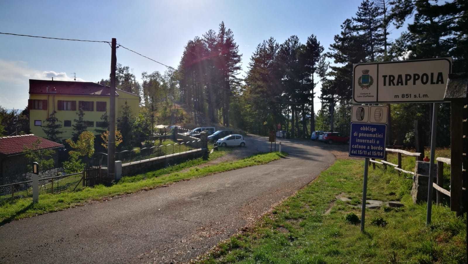 A rural road with a sign for Trappola, a small town.