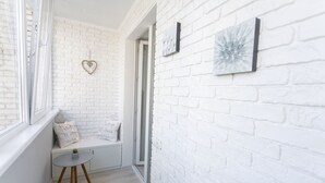 A white brick interior with a bench, a heart-shaped decoration, and two framed artworks. - Royal Suite near Lake (Sumy)