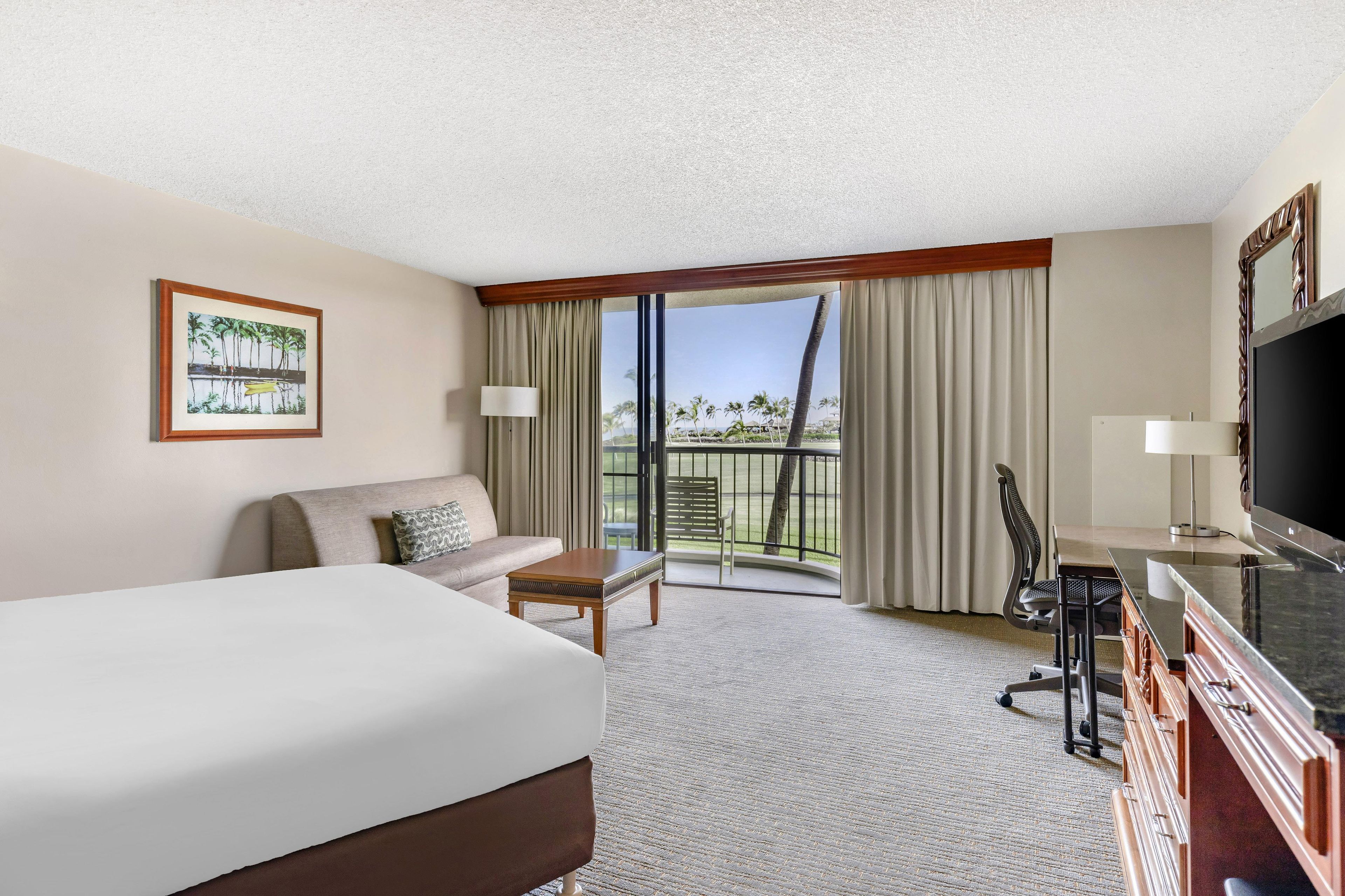 A hotel room with a bed, a sofa, a desk with a chair, a television, and a balcony with curtains.