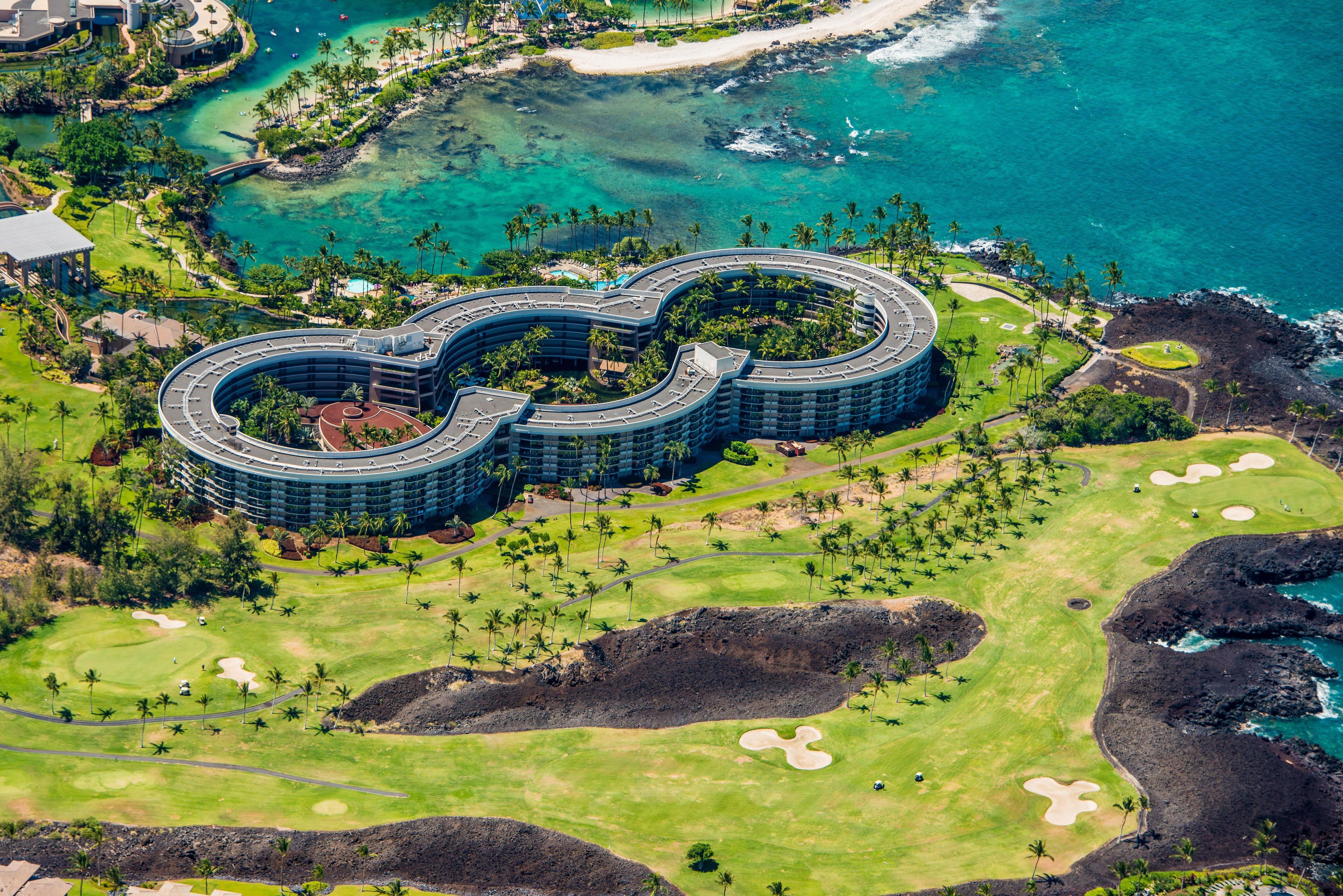Et hotel med en unik, rund arkitektur, omgivet af en golfbane og en strand.