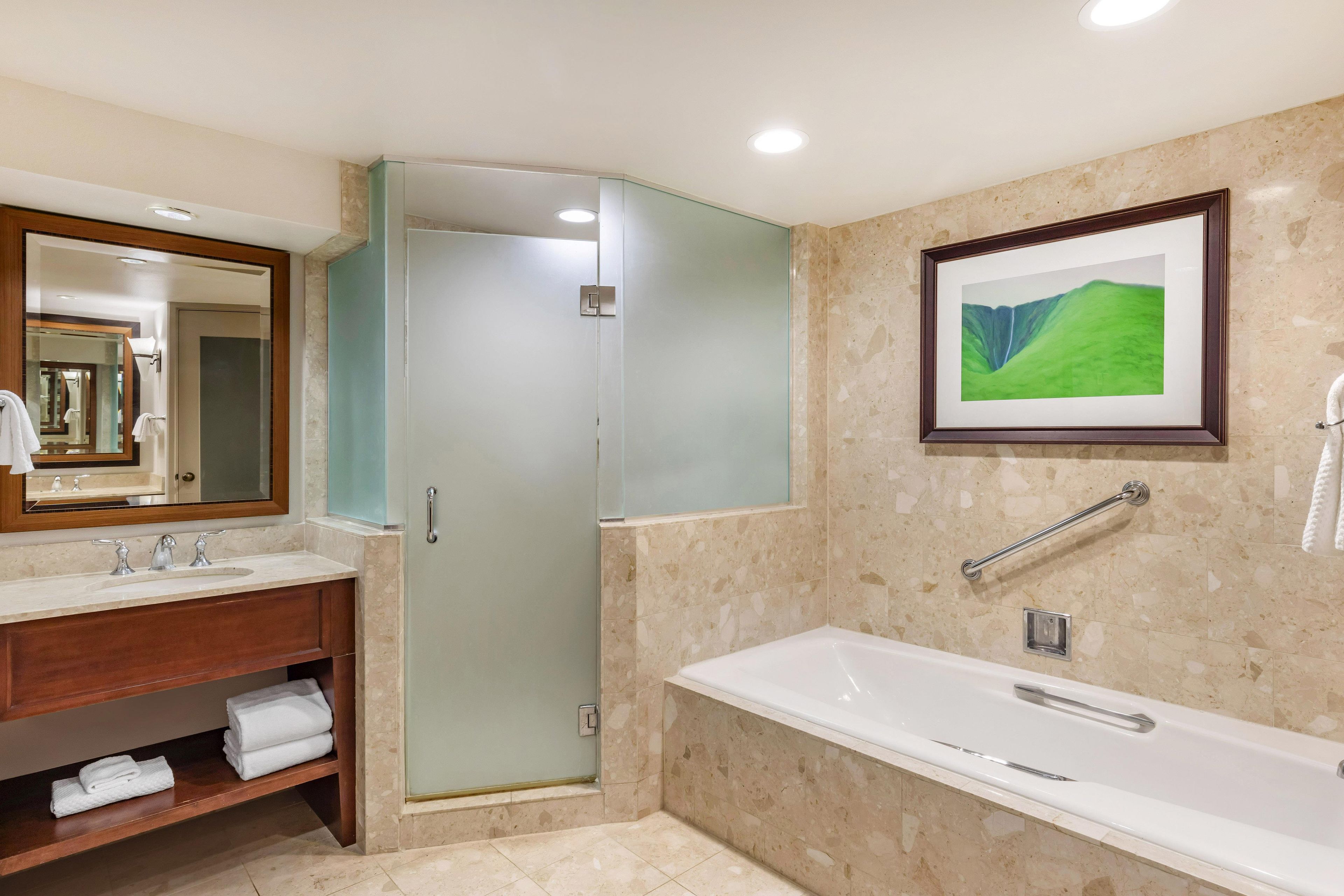 A bathroom with a bathtub, a shower, a sink, and a mirror.