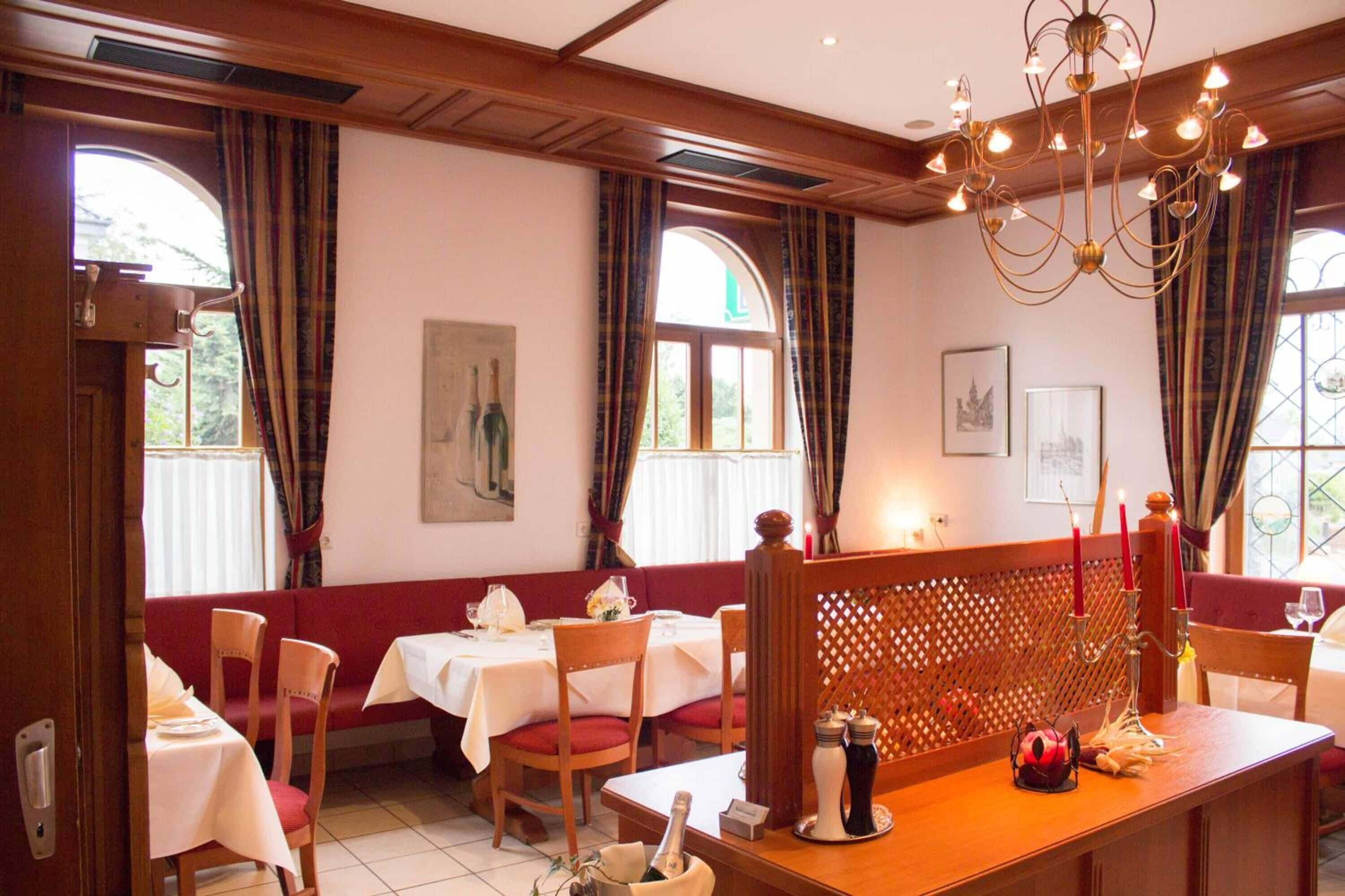 A dining area with tables, chairs, and a wooden partition.