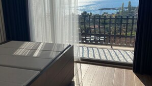 A balcony with a wooden floor and a bed with a mattress.