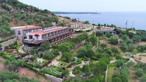 A hotel with a modern design, featuring a rooftop terrace and a landscaped garden.
