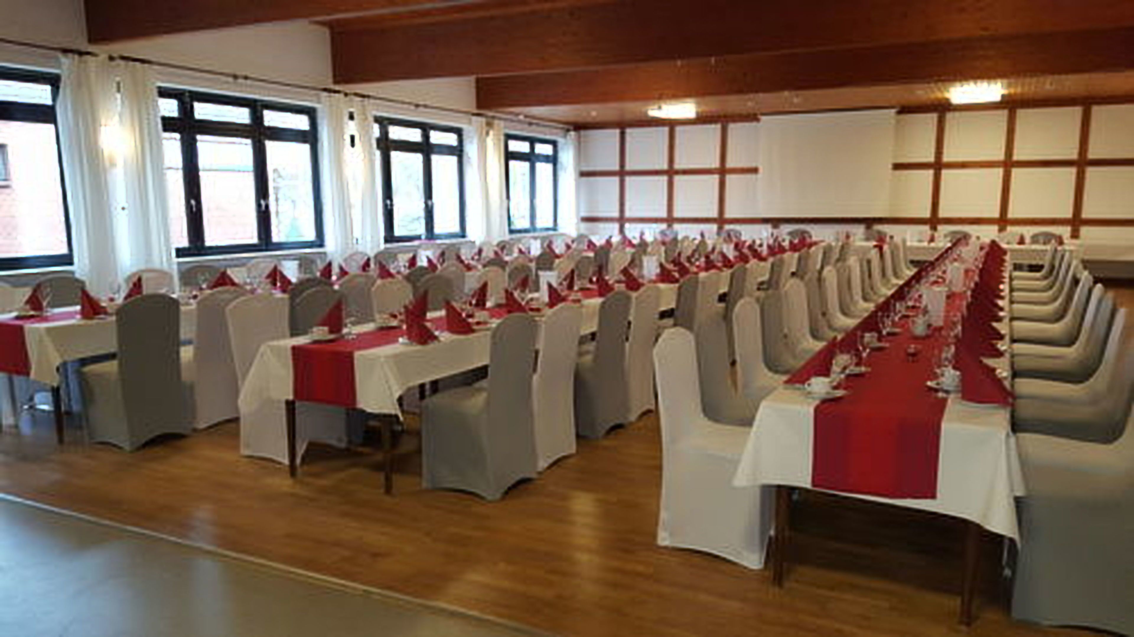 A conference room with rows of tables and chairs, large windows, and a whiteboard.