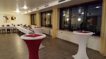 Ett konferensrum med runda bord, vita väggar och stora fönster.