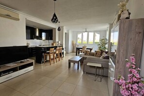 A modern living room with a sofa, coffee table, and TV stand.
