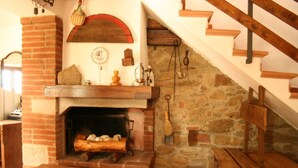 Ein rustikaler Kamin mit Steinwand und einer Holztreppe.