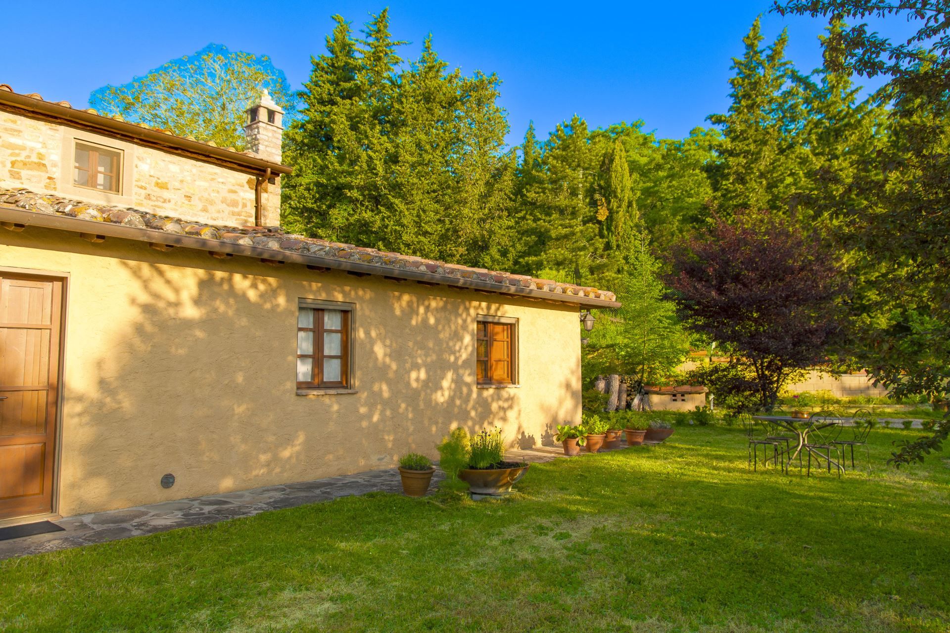 A rustic stone building with a tiled roof, a wooden door, and windows.