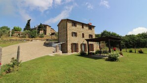 Un bâtiment en pierre doté d’un patio couvert et d  ’un jardin clos.