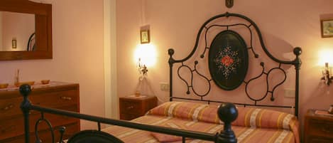 Un dormitorio con cama, cómoda, mesita de noche y espejo en la pared.