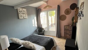 A bedroom with a bed, a desk, a chair, a dresser, and a radiator.