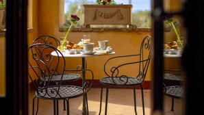 A café with metal chairs and tables, a small table with a vase of flowers, and a view of the outdoors. - Villa with private pool, tennis court and table tennis located in Castiglion Fiorentino. Panoramic p (Castiglion Fiorentino)