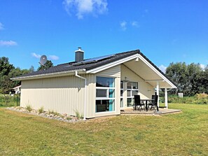 Enjoy outdoor dining or relaxation on the covered patio with a table and chairs.