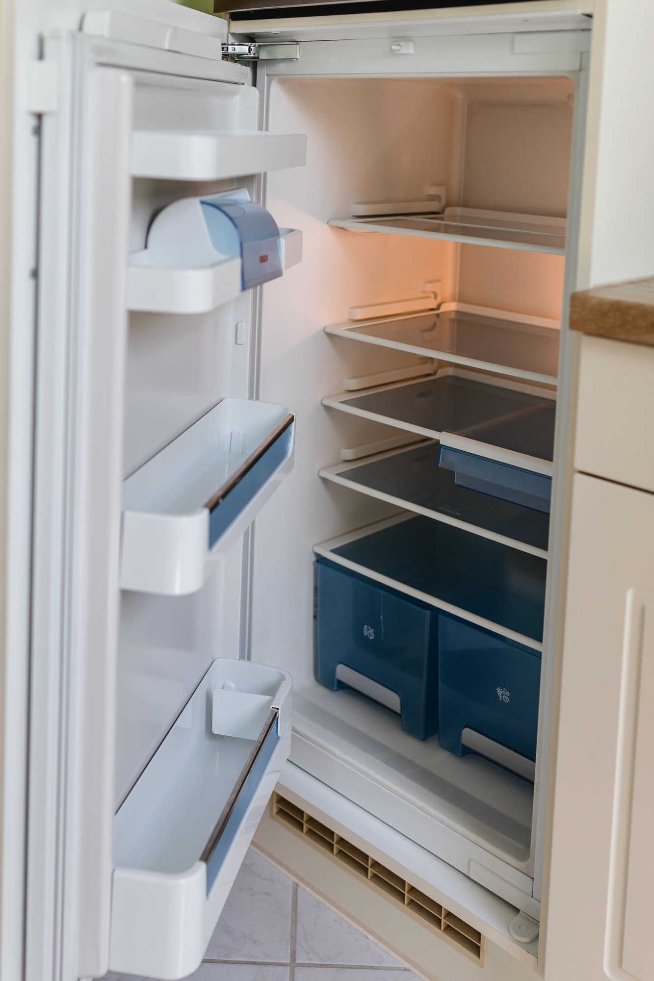 A refrigerator with multiple shelves and drawers, some of which are empty.
